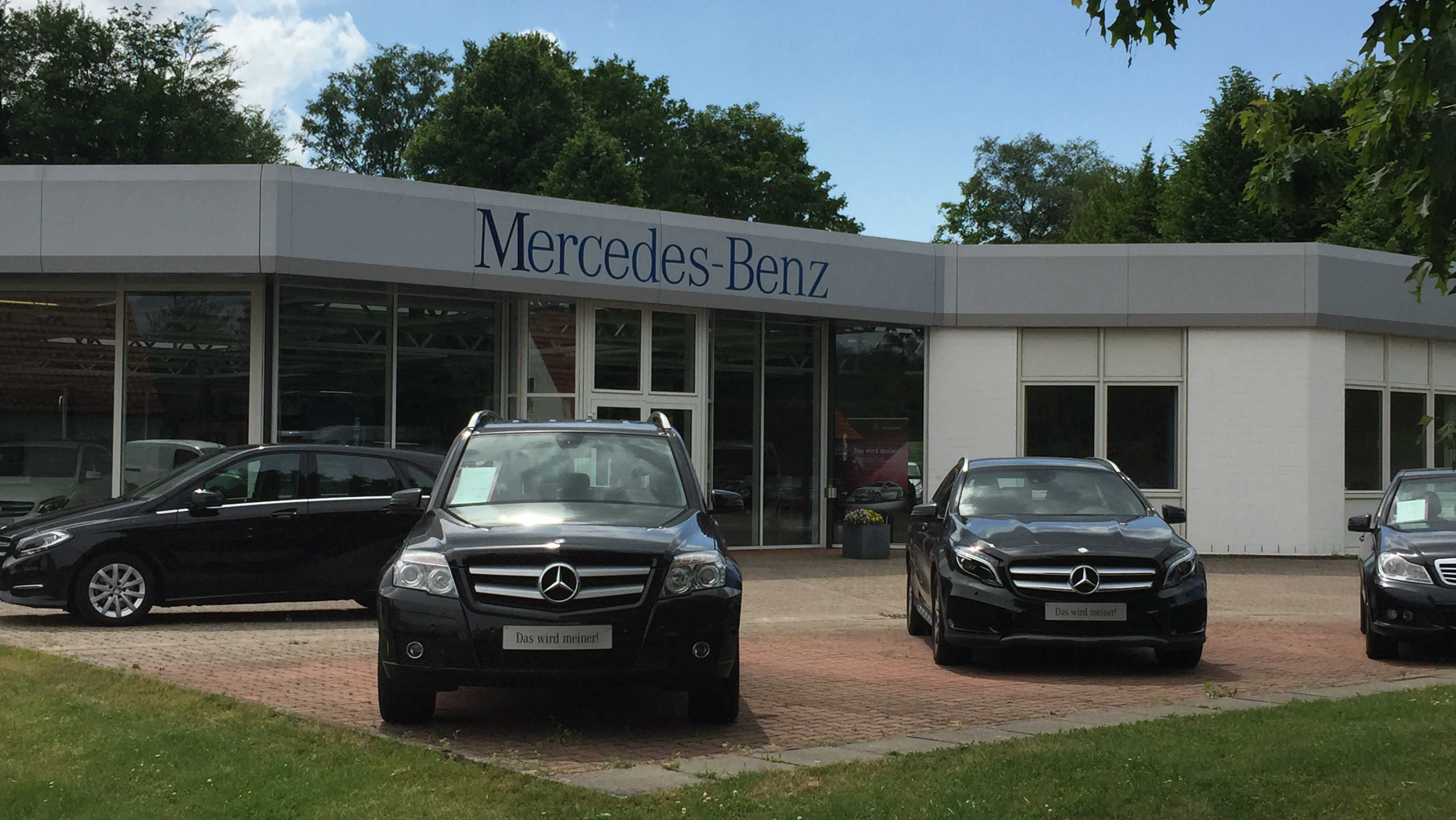 Ein Mercedes-Benz-Autohaus mit schwarzen Autos im Vordergrund