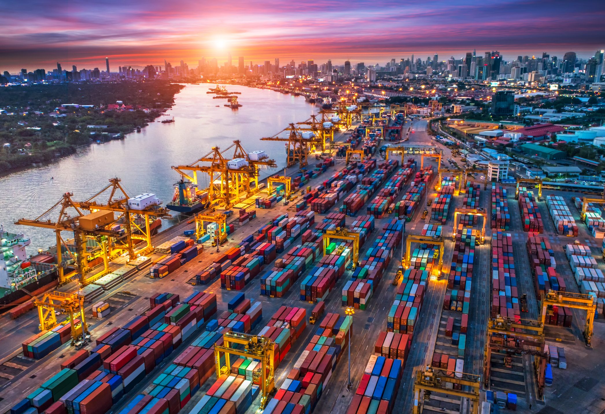 Containerhafen am Fluss mit Sonnenuntergang