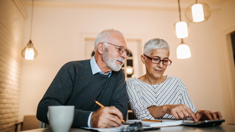 Mature couple doing some paperwork and calculations at home Aktien