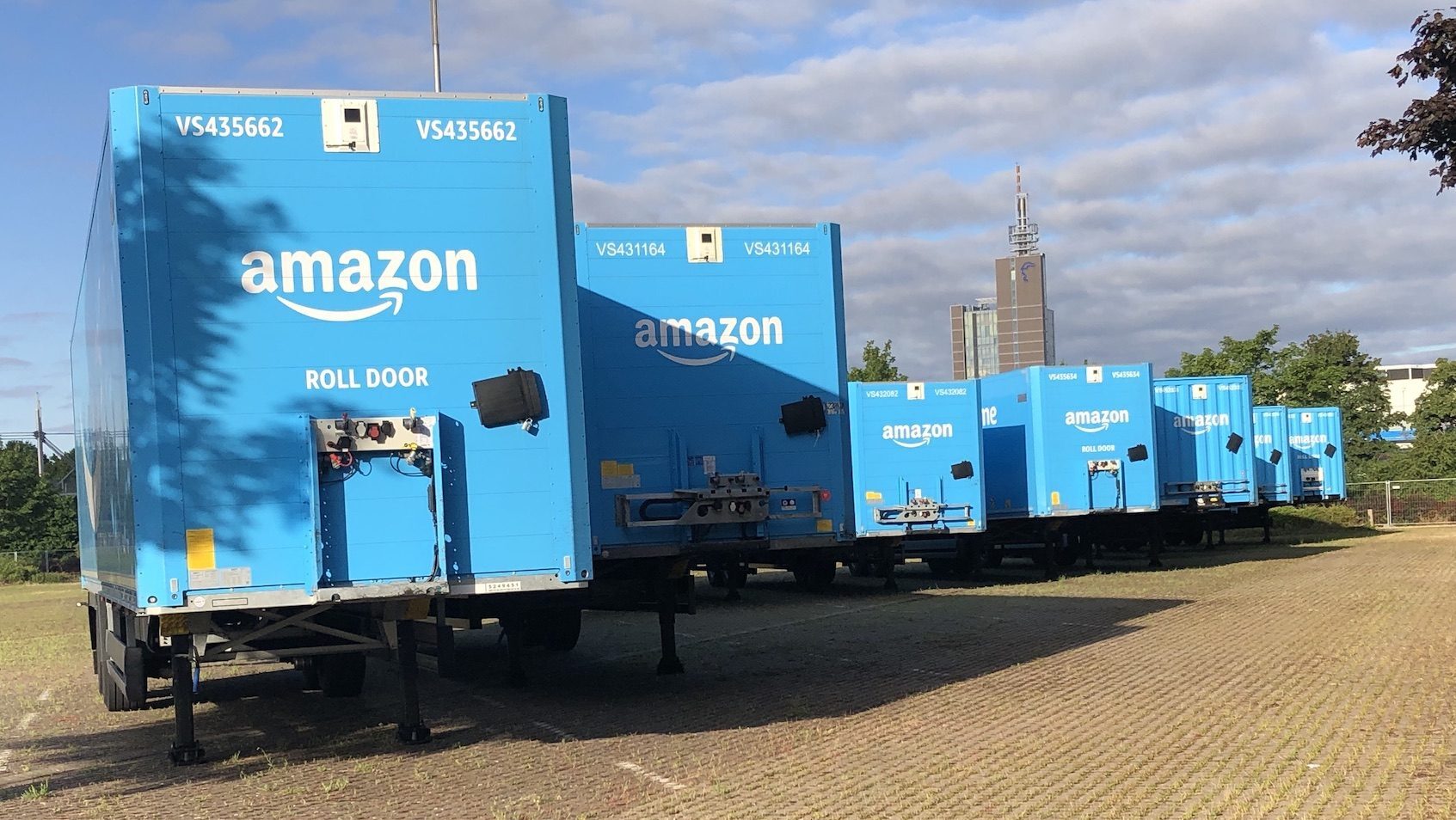 Hellblaue Amazon-Anhänger auf einem Parkplatz
