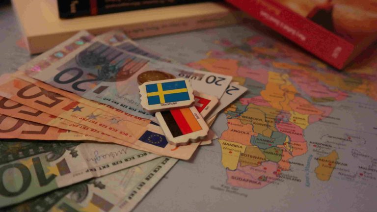 Geld Euro liegen auf einer Landkarte und verschiedenen internationalen Flaggen
