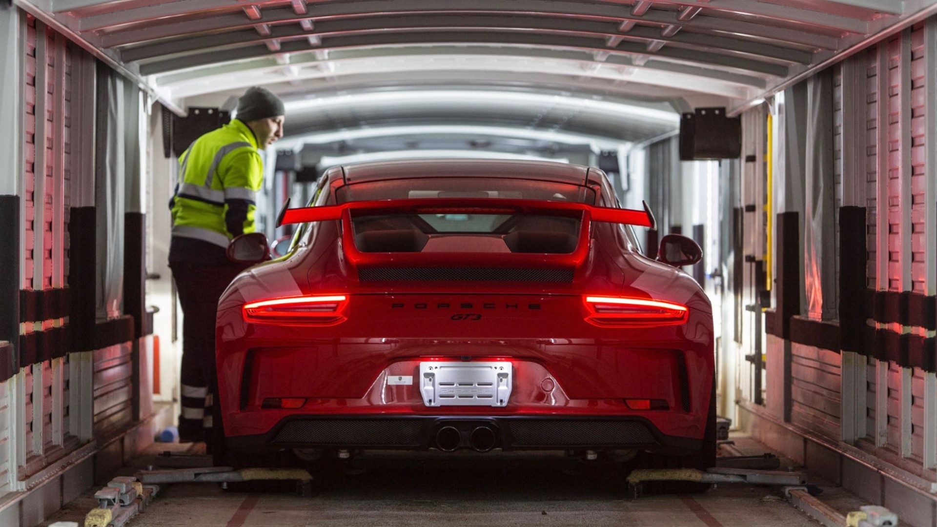 Ein Porsche 911 GT3 Sportwagen wird von hinten bei einem Transport gezeigt.