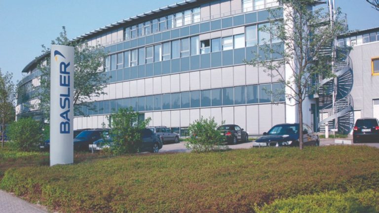 Hauptsitz der Firma Basler in Ahrensburg mit Autos auf dem Parkplatz davor.