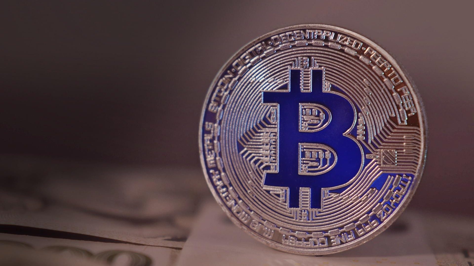 Eine goldene Bitcoin-Münze mit dem Bitcoinlogo eingraviert.