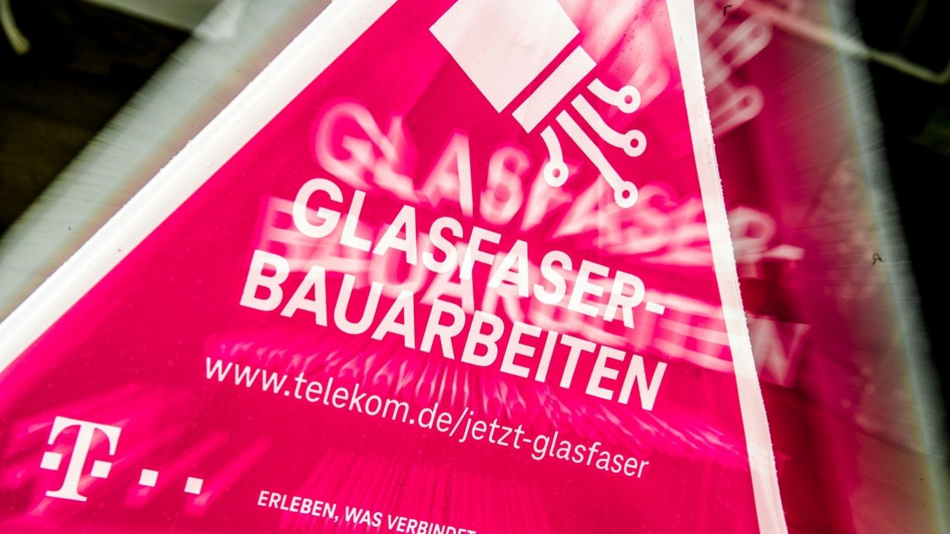 Ein magentafarbenes Hinweisschild der Deutschen Telekom über Glasfaser-Bauarbeiten für schnelleres Internet