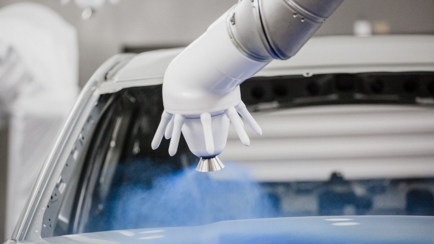Der EcoBell3 E von Dürr sprüht gleichmäßig blauen Lack auf ein Auto