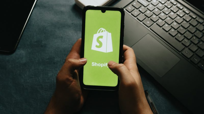 Ein Smartphone, auf dem das Logo des E-Commerce-Unternehmens Shopify zu sehen ist