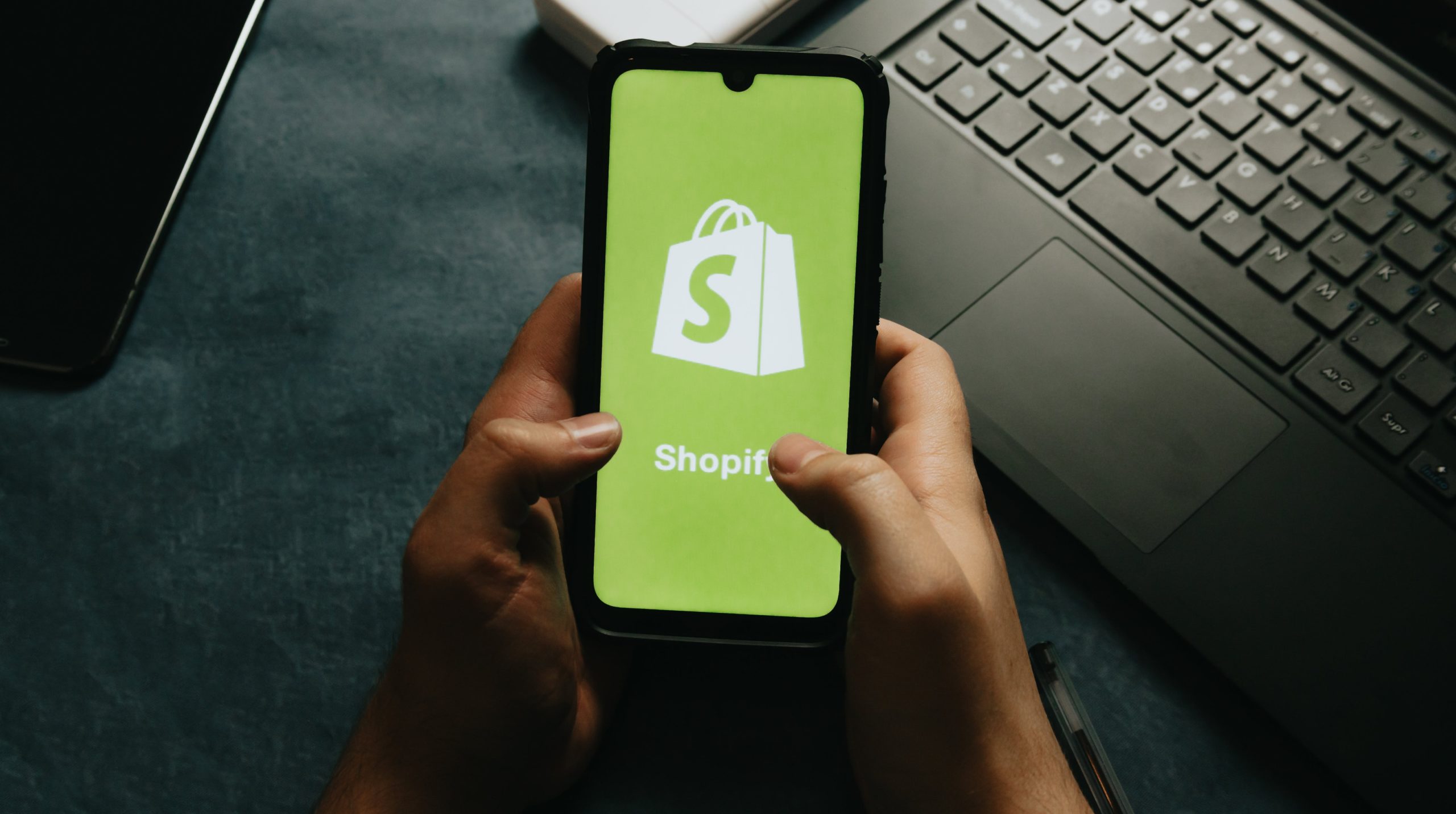 Ein Smartphone, auf dem das Logo des E-Commerce-Unternehmens Shopify zu sehen ist