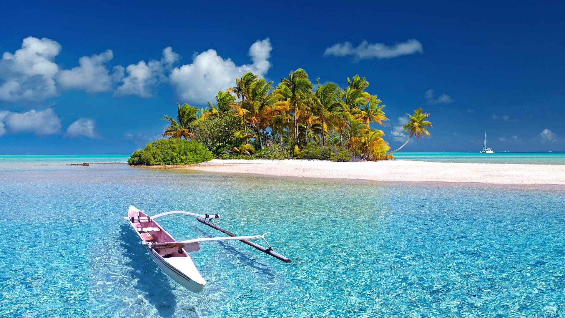 Eine einzelne Insel mit einem Kanu im Vordergrund, klarem Wasser und Sandstrand.