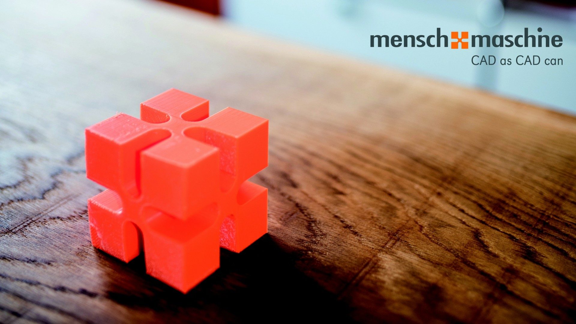 Ein orangeroter Würfel, der das Logo des CAD-Unternehmens Mensch und Maschine imitiert