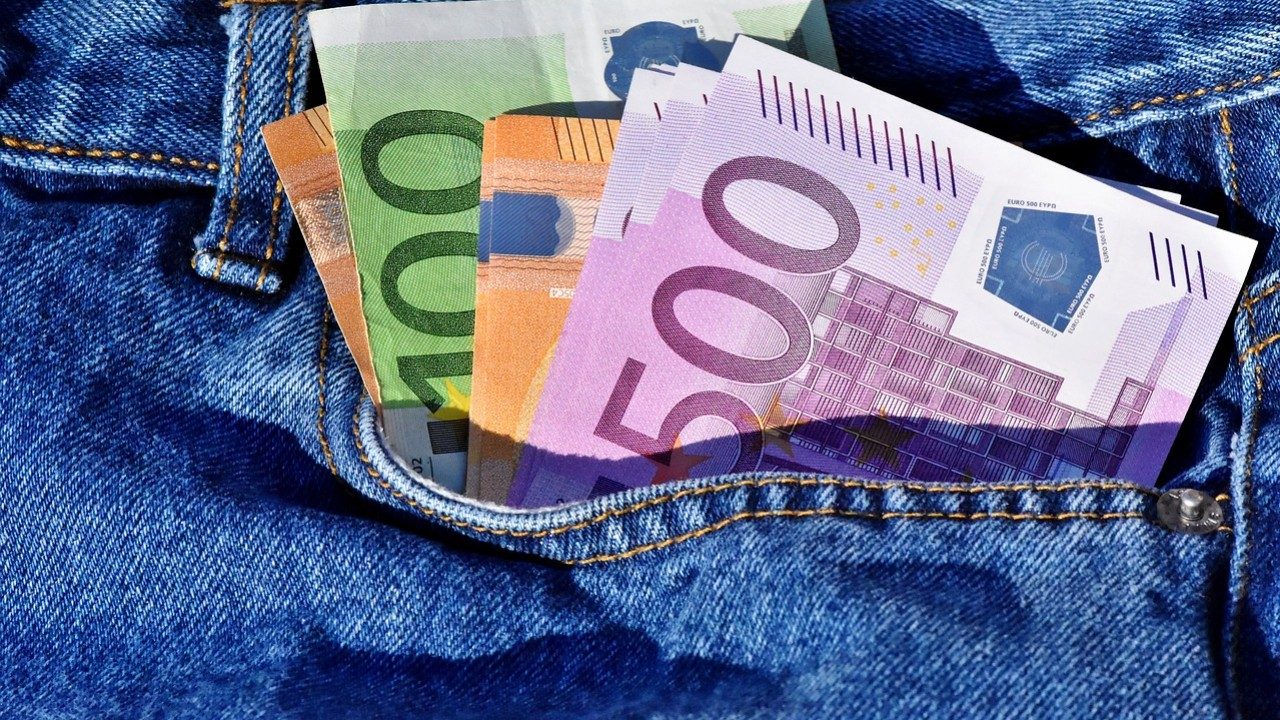 Diverse Geldscheine in einer Jeans-Hosentasche