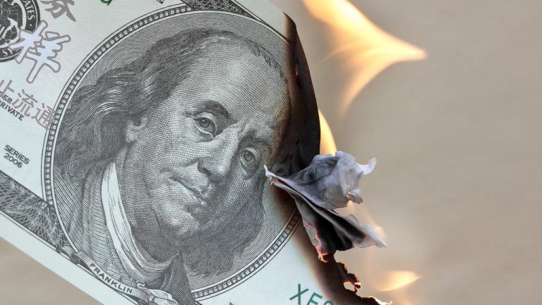 Ein Dollar-Geldschein brennt und steht in Flammen