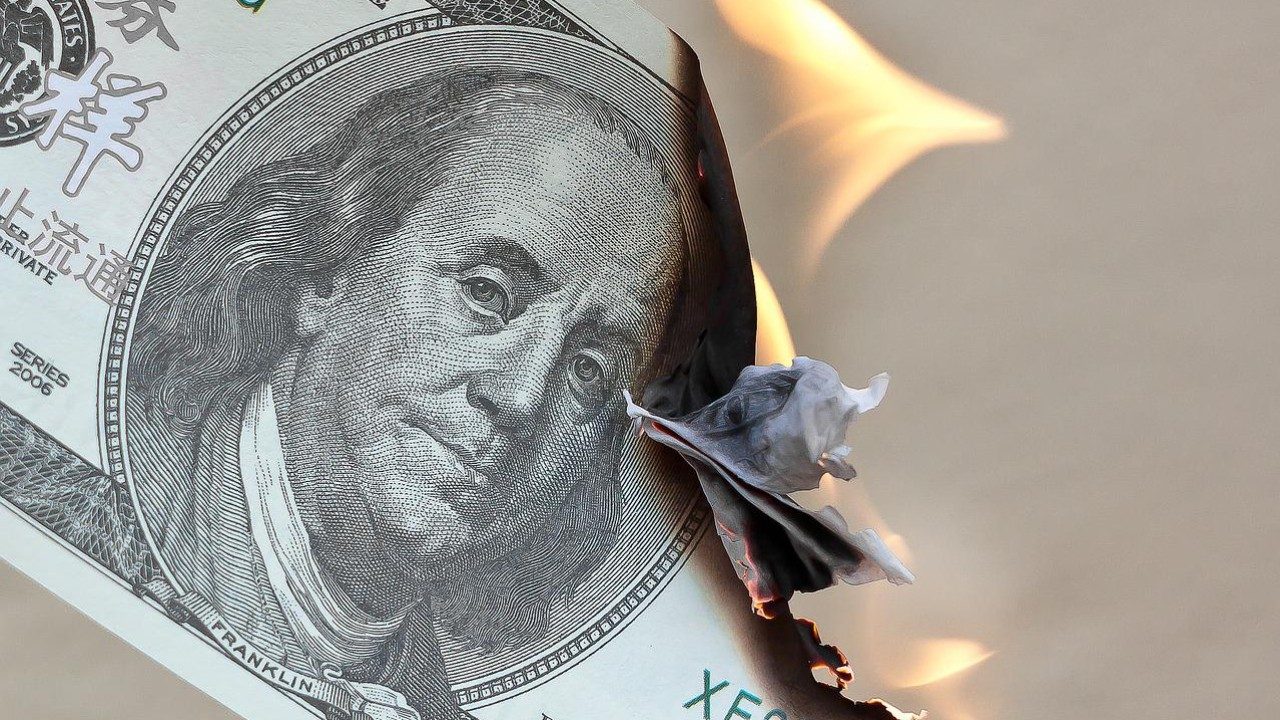 Ein Dollar-Geldschein brennt und steht in Flammen