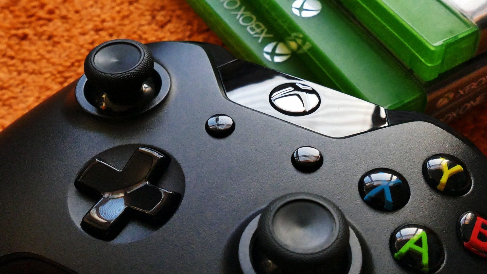 Ein Xbox-Controller neben drei Videospiele-Verpackungen