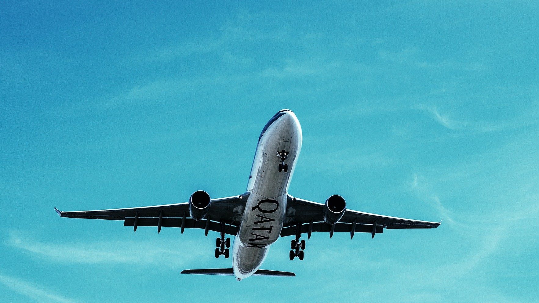 Ein Qatar Airways-Flugzeug setzt vor blauem Himmel zur Landung an