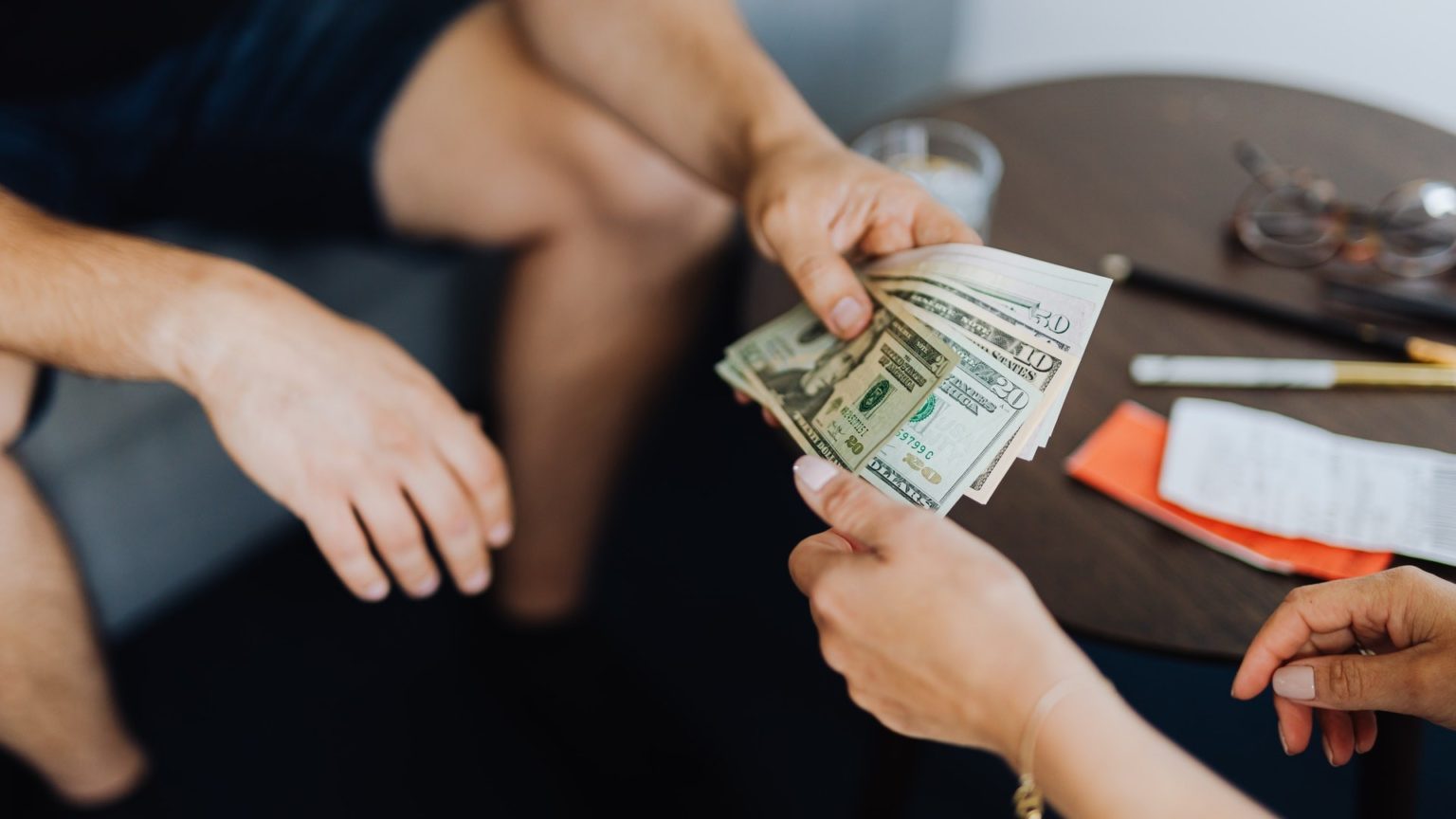Ein Mann bezahlt eine andere Person mit Bargeld