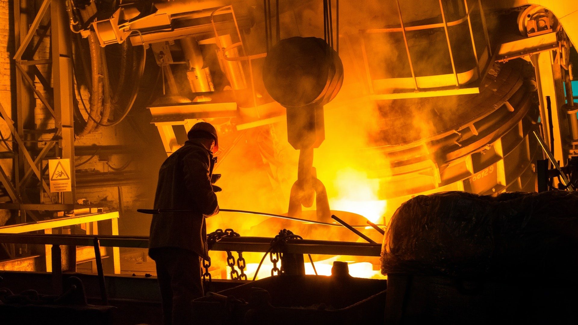 Ein Mann in einer Stahlhütte überwacht die Produktion des Metalls