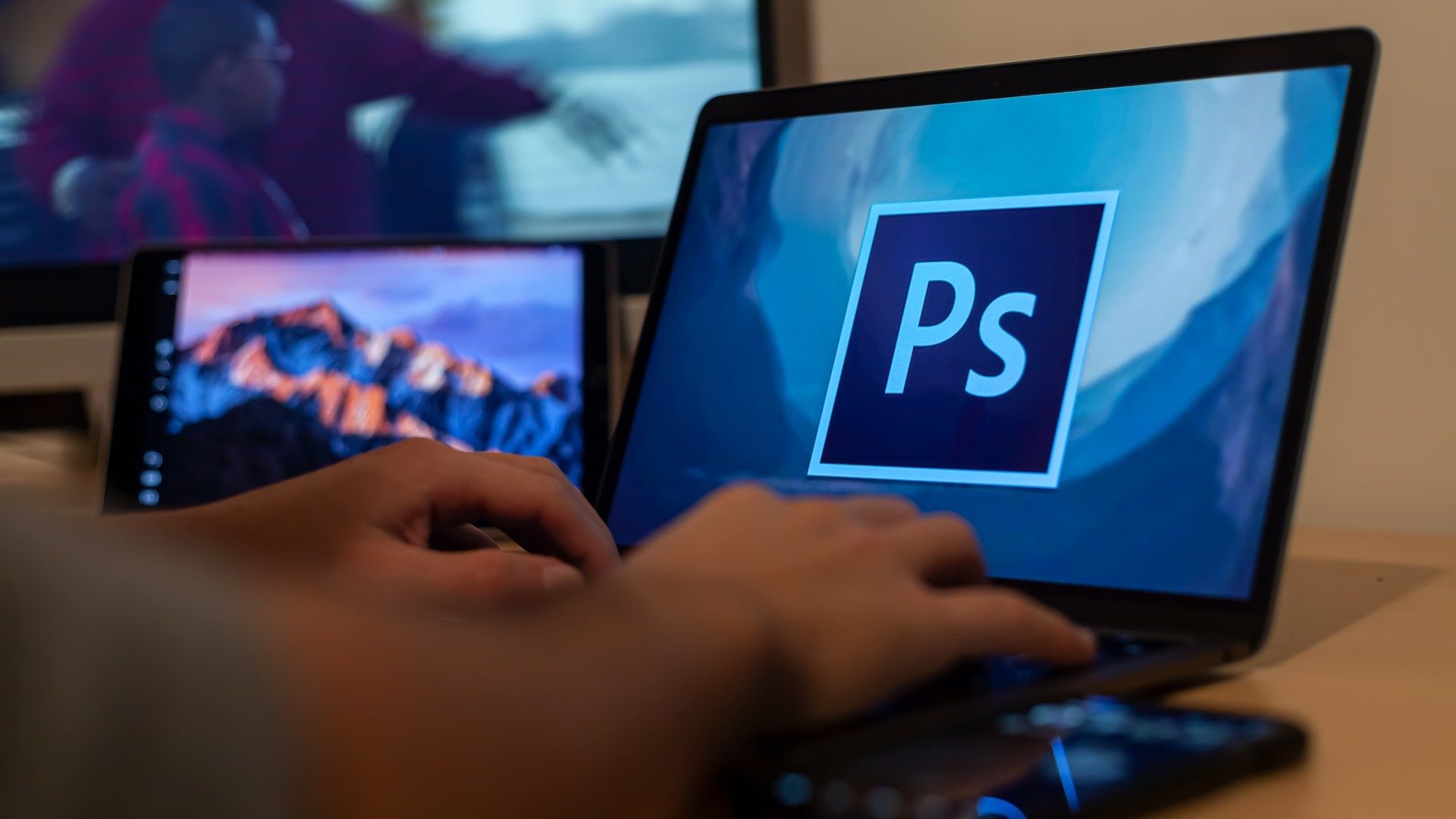 Eine Person arbeitet kreativ an einem Laptop, der das Adobe Photoshop-Logo zeigt