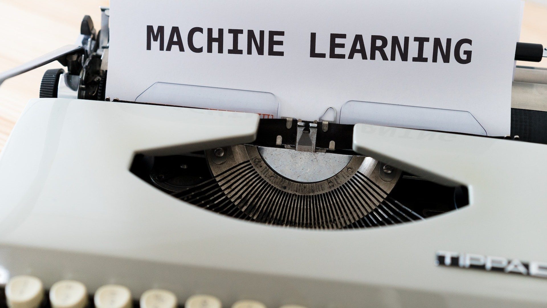 Eine Schreibmaschine tippt das Wort "Machine Learning", eine Form der Künstlichen Intelligenz