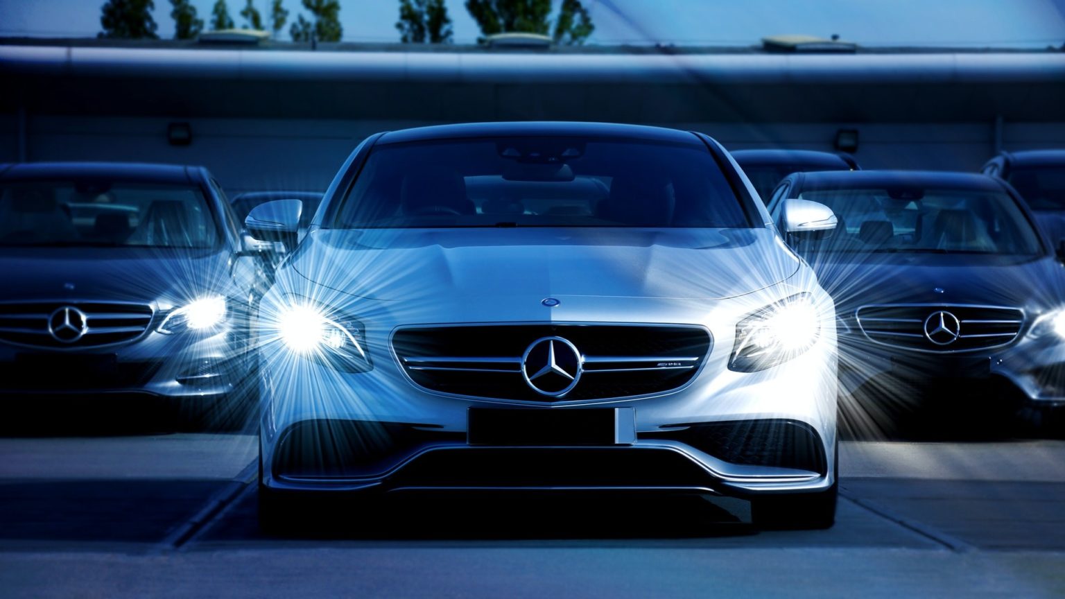 Drei Autos von Mercedes-Benz auf einem Parkplatz