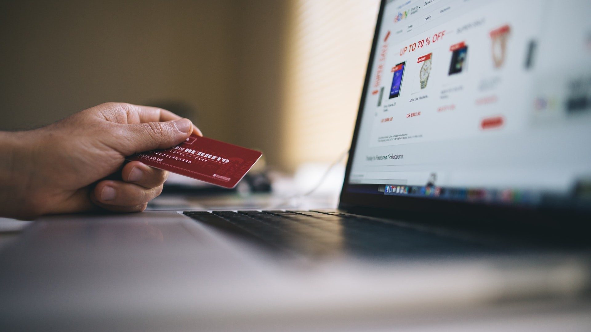 Eine Person nutzt ihre Kreditkarte zum Onlineshopping im Internet