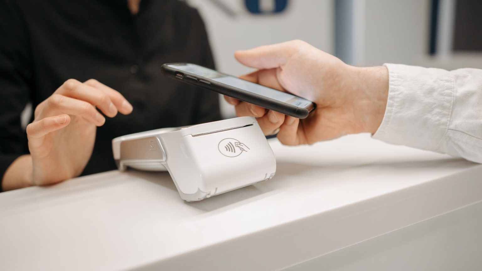 Eine Person bezahlt im Einzelhandel kontaktlos mit dem Smartphone
