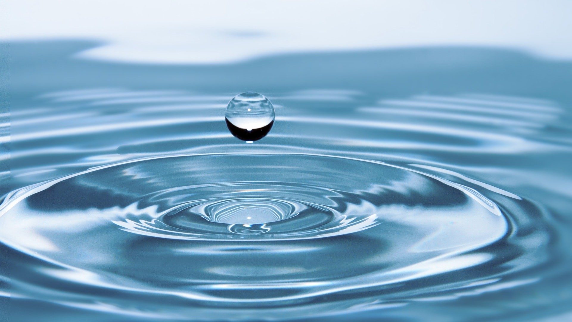 Ein Wassertropfen der gerade im Meer eintaucht.