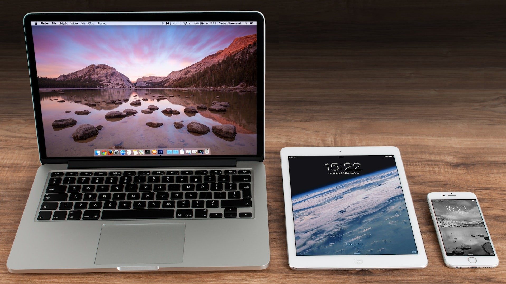 Die Apple-Produkte MacBook, iPad und iPhone auf einem Holztisch