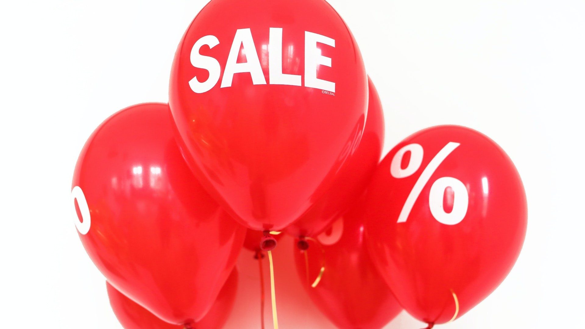 Rote Luftballoons mit der Aufschrift Sale und Prozentzeichen.