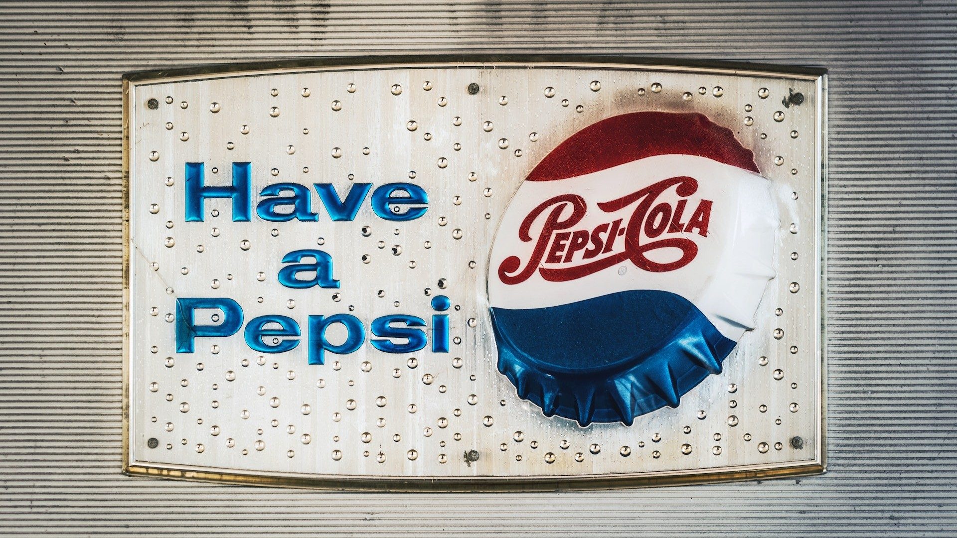 Ein Schild mit der Aufschrift "Have A Pepsi" und einem Pepsi-Cola-Kronkorken