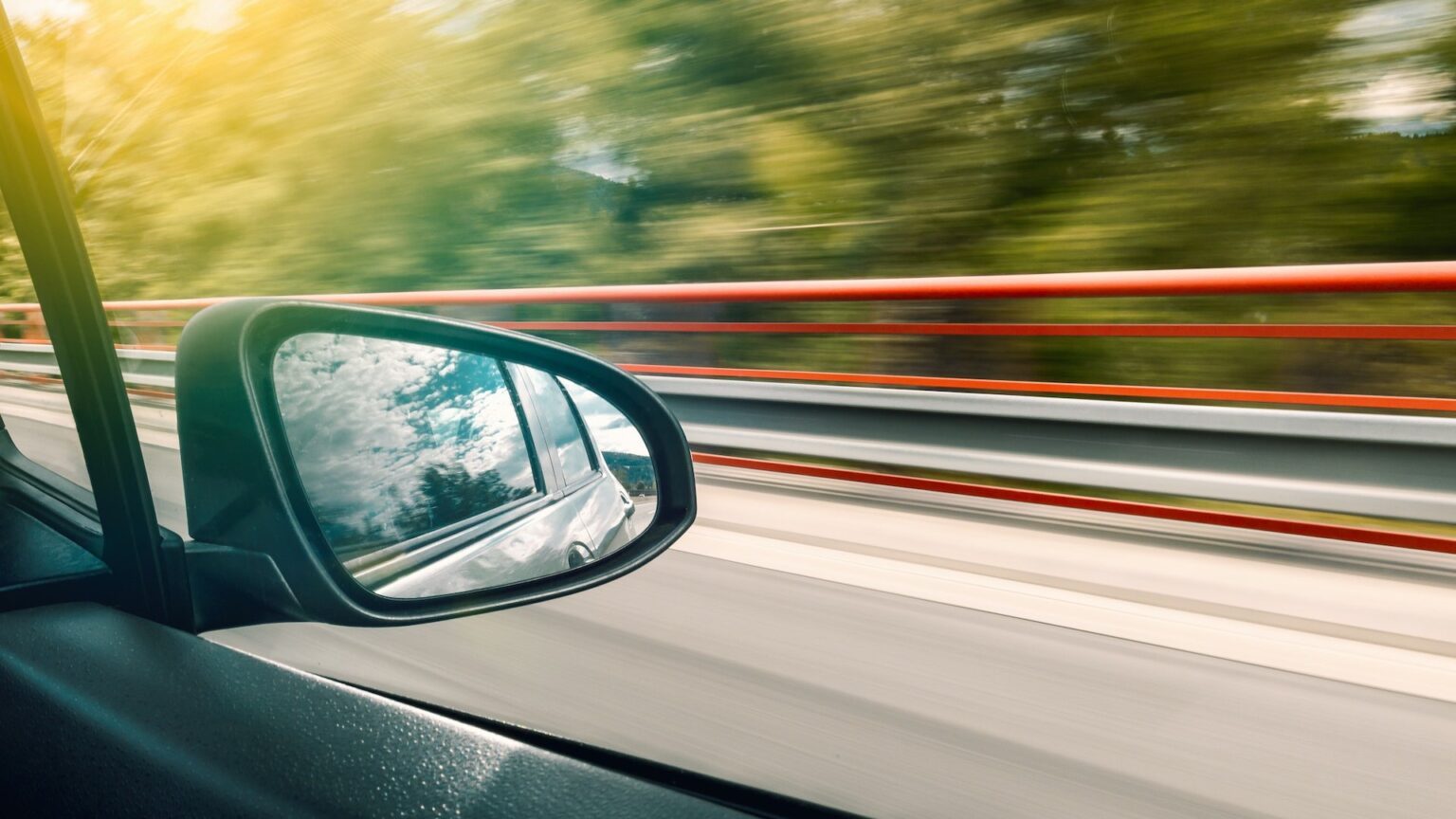 Blick auf den Rückspiegel eines fahrenden Autos