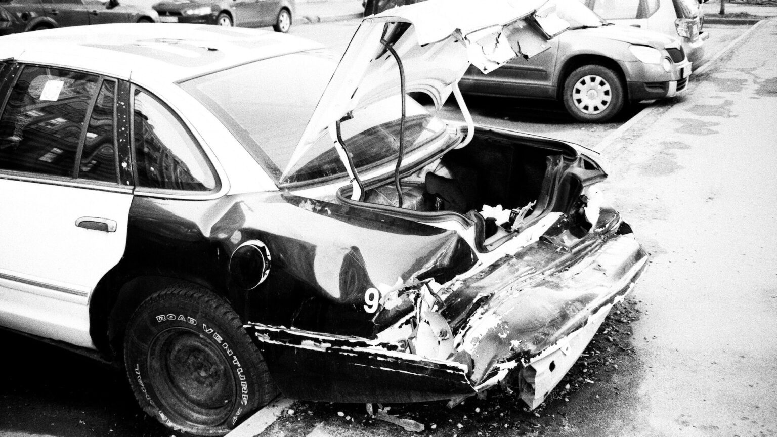 Ein Oldtimer mit zerstörter Heckklappe auf einem Parkplatz
