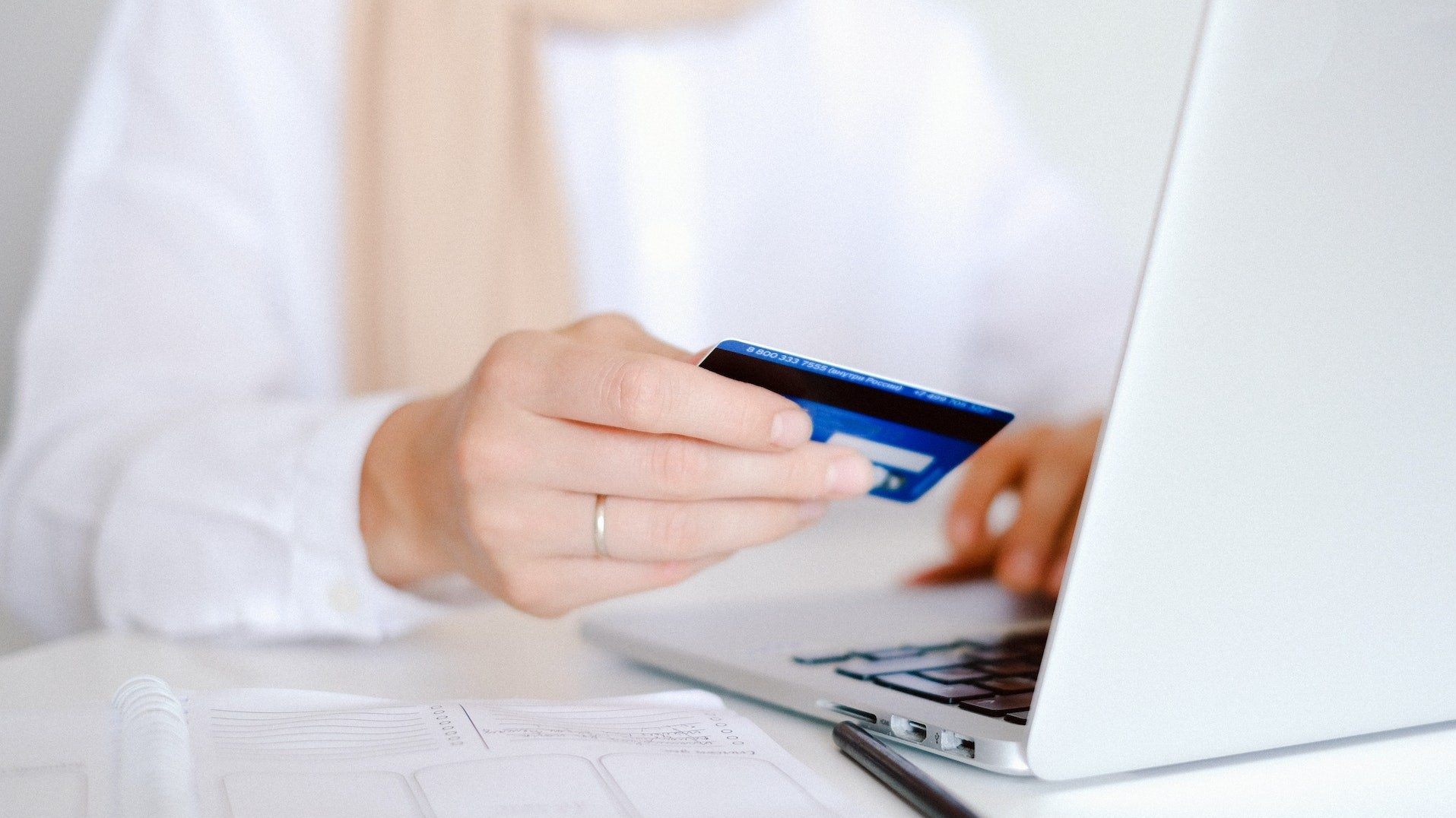 Eine Person bezahlt beim Onlineshopping mit der Kreditkarte im Internet