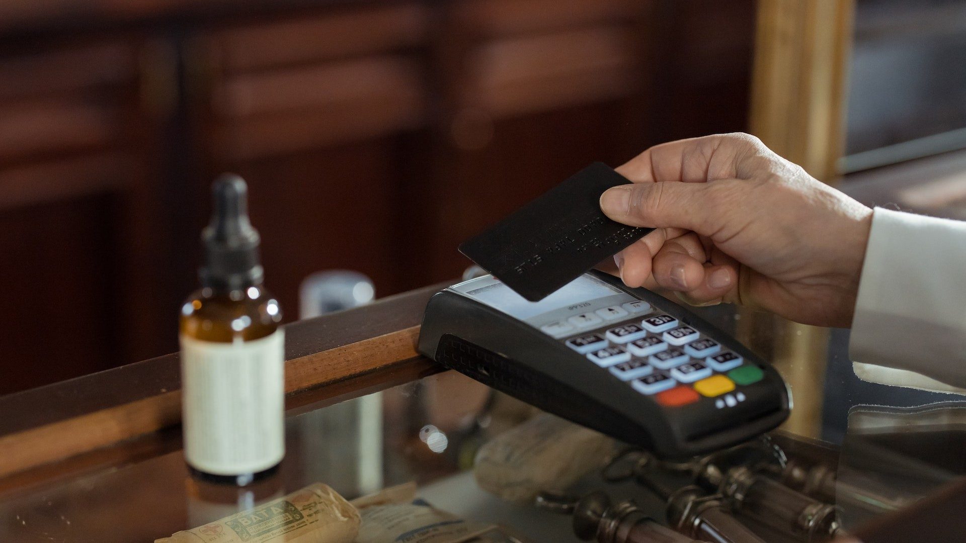 Eine Person bezahlt im Einzelhandel kontaktlos mit einer Kreditkarte