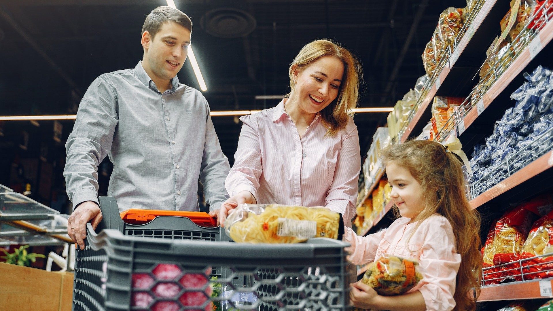 Vater, Mutter und Kind beim Einkaufen im Supermarkt