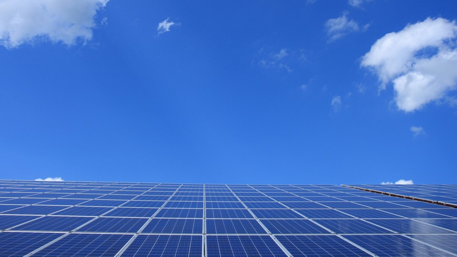 Solarzellen unter dem blauen Himmel produzieren grünen Strom aus der Energie der Sonne