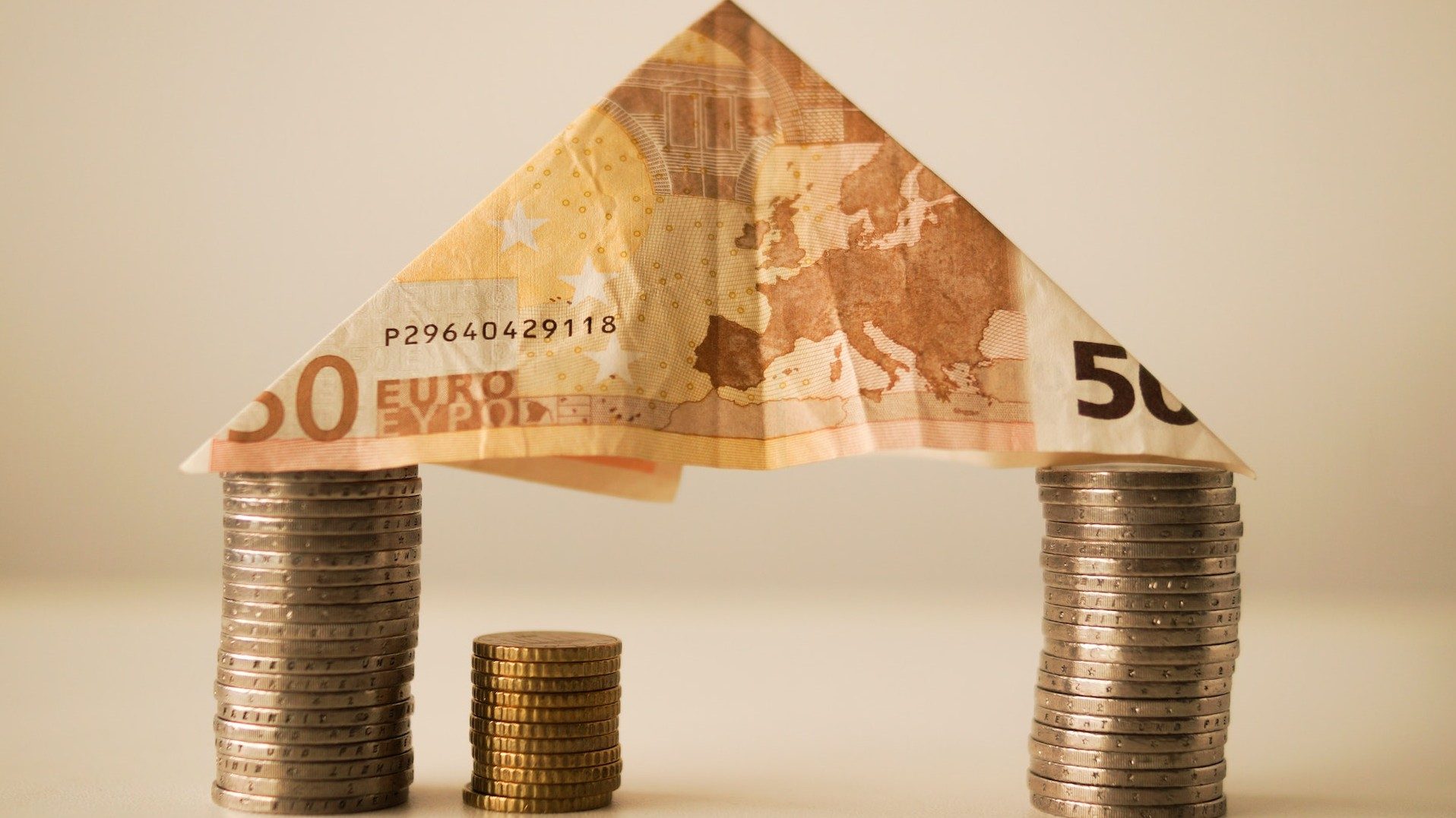 Ein Haus aus Euro-Münzen und einem gefalteten 50-Euro-Schein