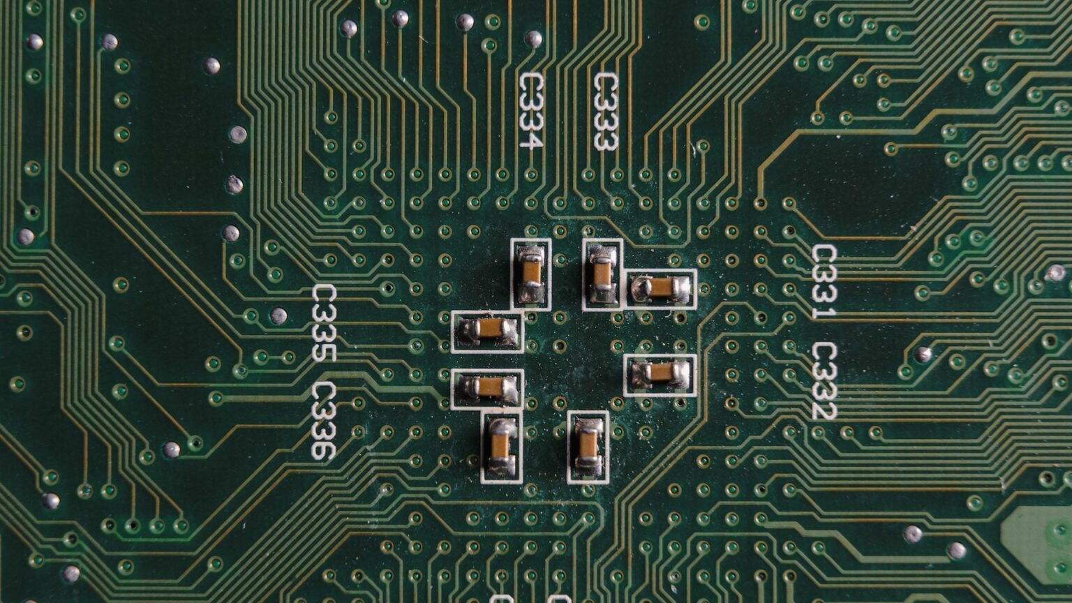 Nahaufnahme von winzigen Leitungen auf einem grünen Computerchip