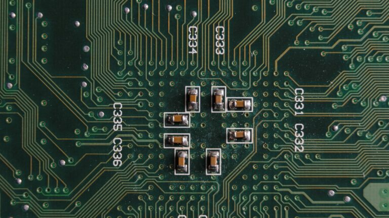 Nahaufnahme von winzigen Leitungen auf einem grünen Computerchip