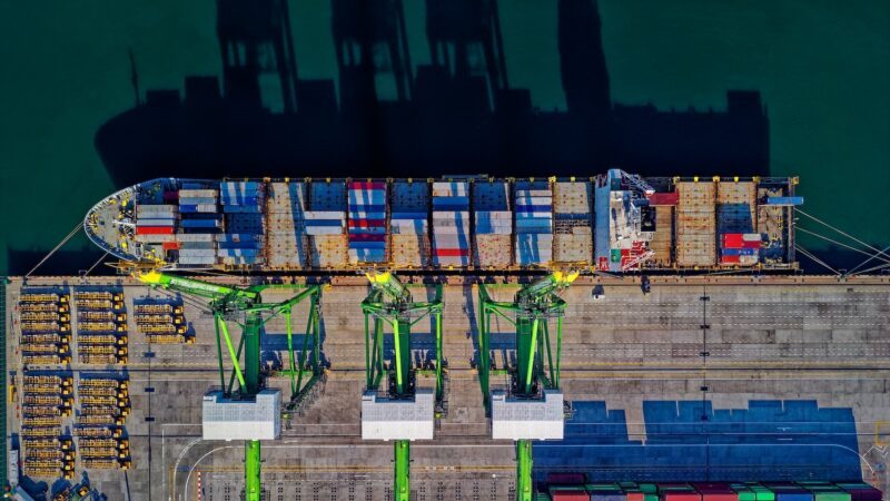 Luftaufnahme eines Containerschiffs im Hafen, das be- oder entladen wird