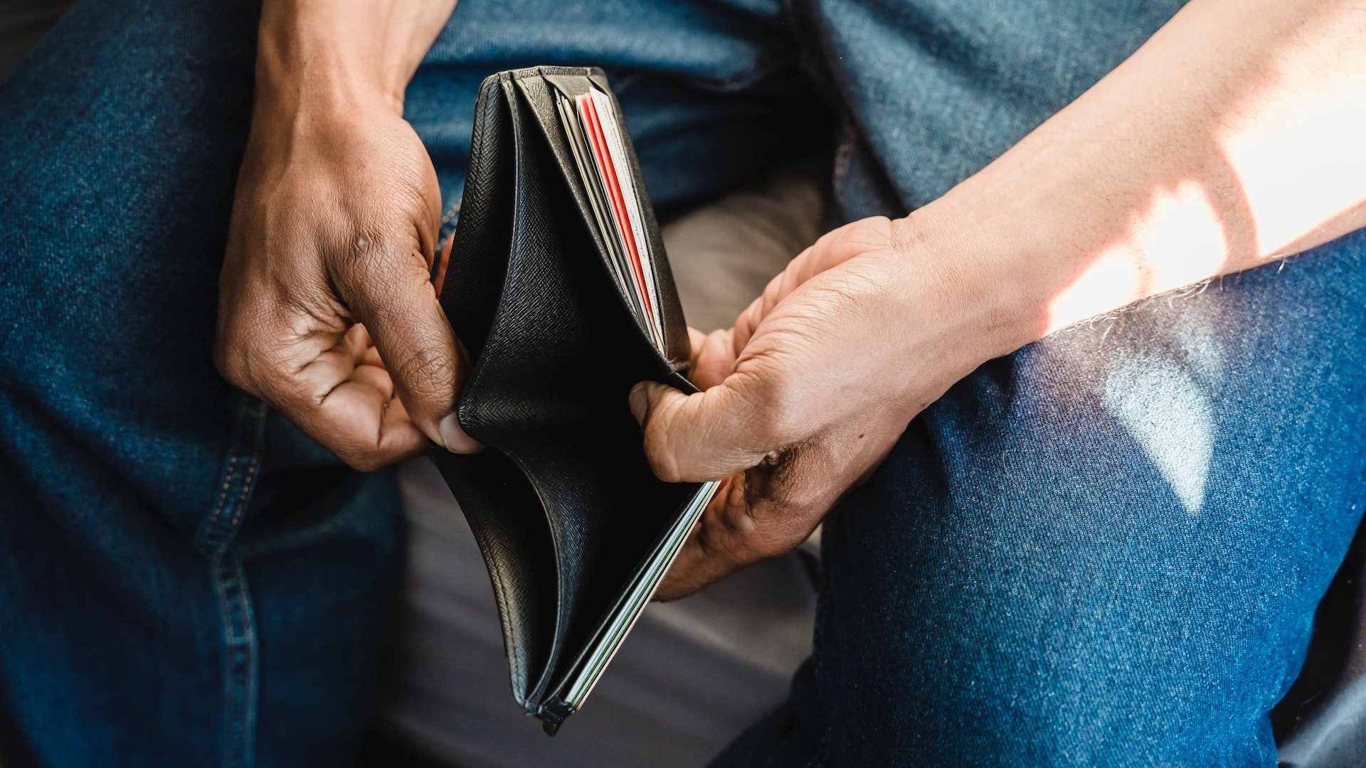 Ein Mann hält sein leeres Portmonee geöffnet