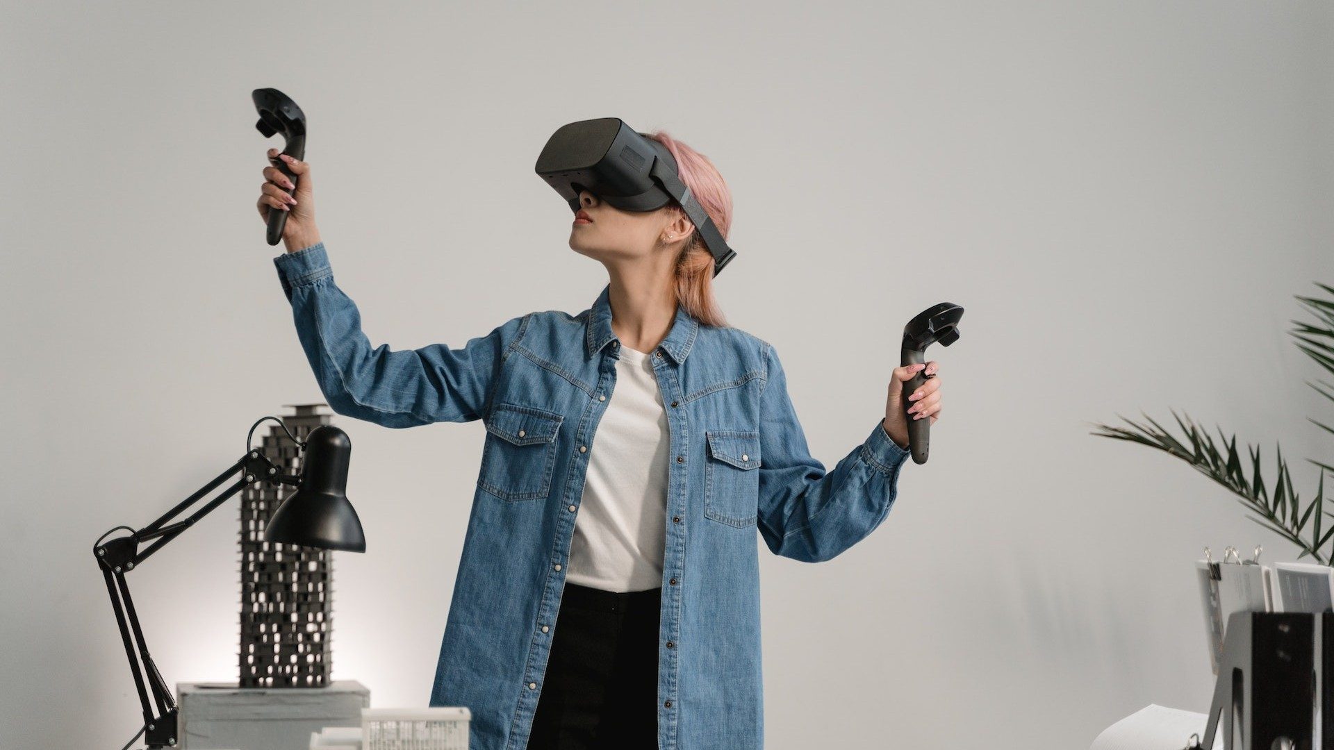 Eine Frau nutzt Virtual-Reality-Controller und eine VR-Brille