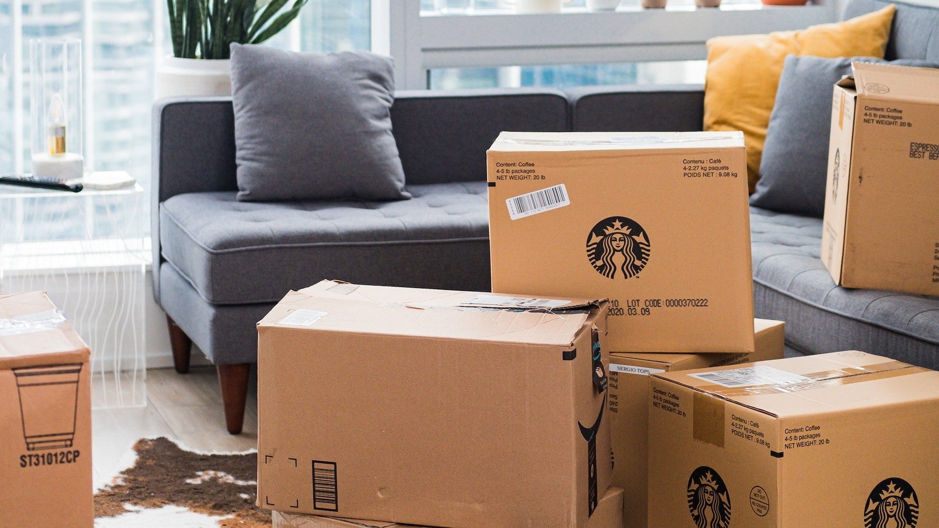 Pakete, unter anderem von Starbucks, in einem Wohnzimmer