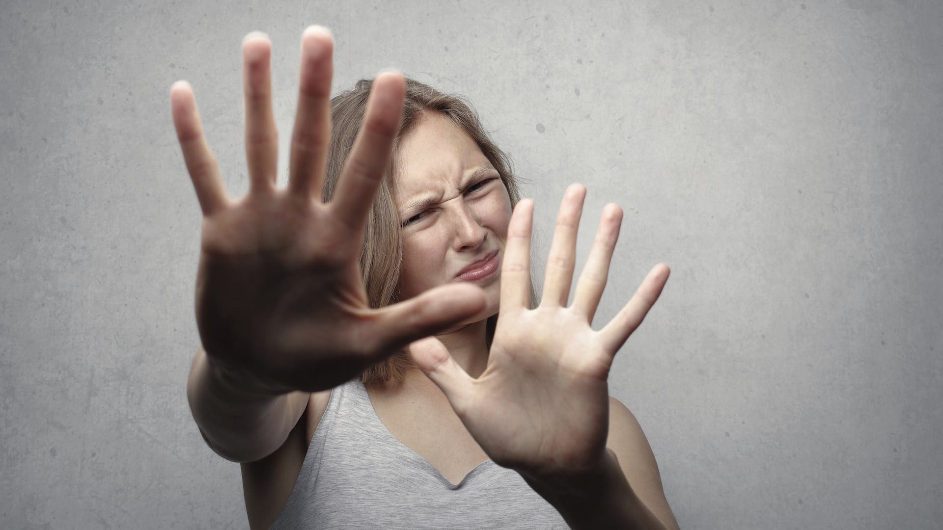Abstand, bitte: Eine Frau streckt die Hände vor sich aus und verzieht das Gesicht