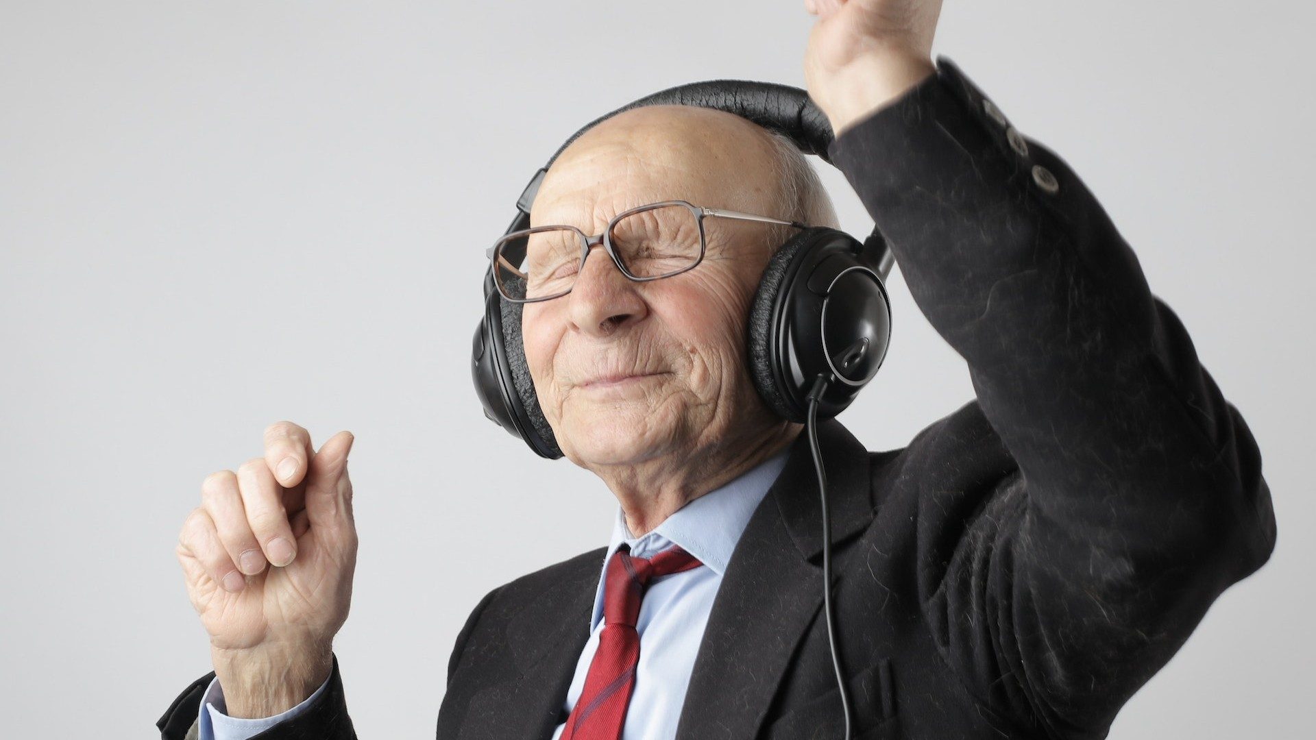 Ein alter Mann tanzt vergnügt zu Musik au seinen Kopfhörern