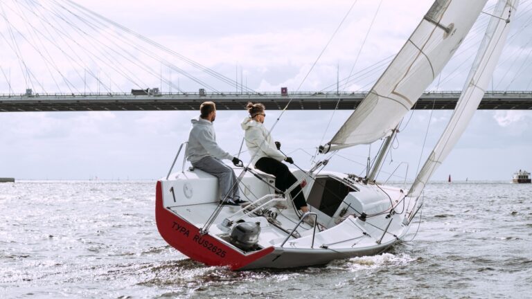 Zwei Männer steuern ihr Segelboot durch ein Gewässer