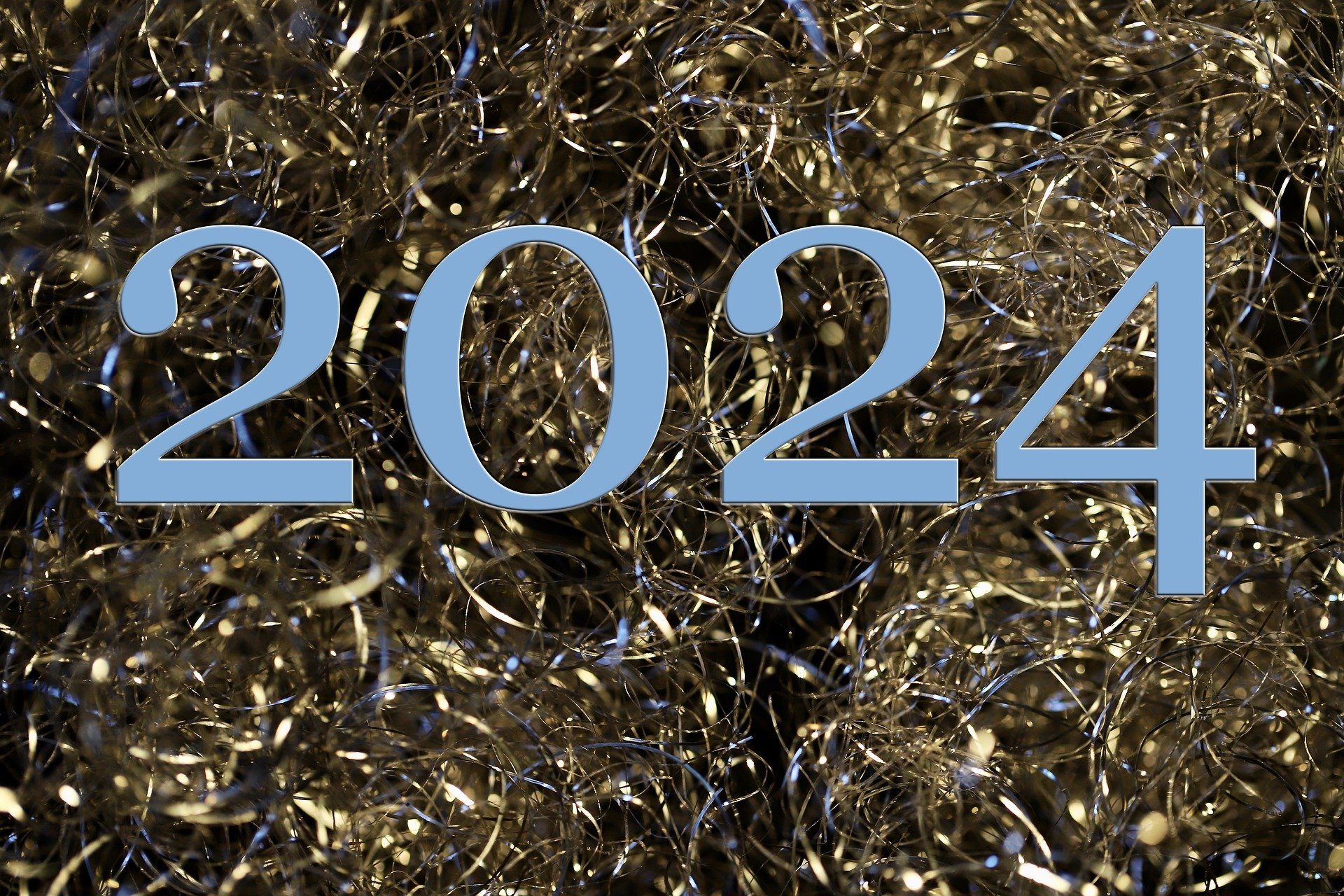 Schriftzug 2024 vor festlicher, glitzernder Dekoration