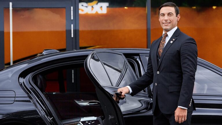 Ein Sixt-Mitarbeiter öffnet die Tür eines Mietwagens