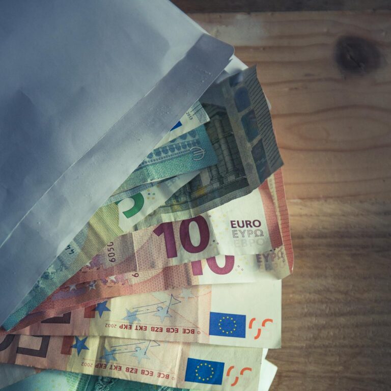 Euro-Geldscheine und ein Umschlag liegen auf dem Tisch