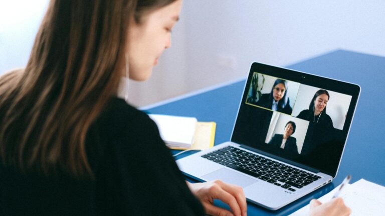 Eine Frau nimmt an einem Videocall mit drei weiteren Personen teil